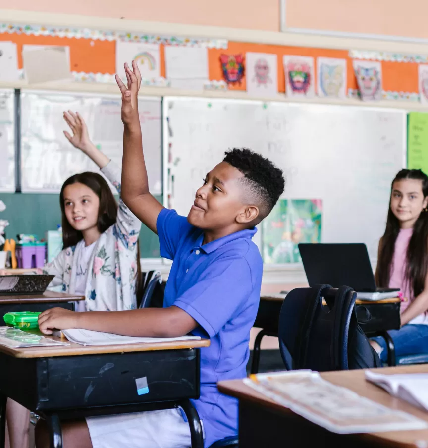 A pupil raising a hand in a primary classroom